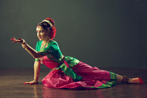 Girl, dressed in traditional national costume, dancing classical indian dance Kuchipudi. Emotional gestures of indian dance kuchipudi.